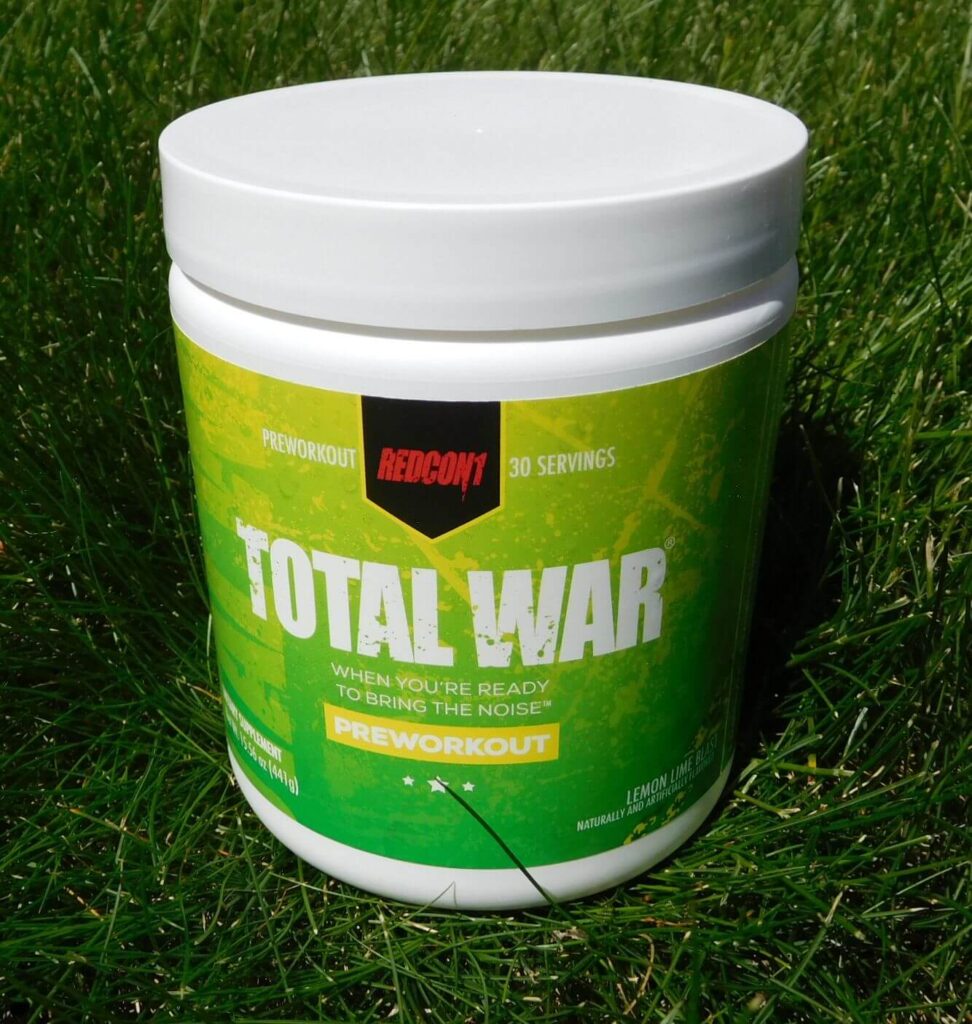 tub of redcon1 total war lemon lime flavored 30-serving preworkout powder mix sitting in grass