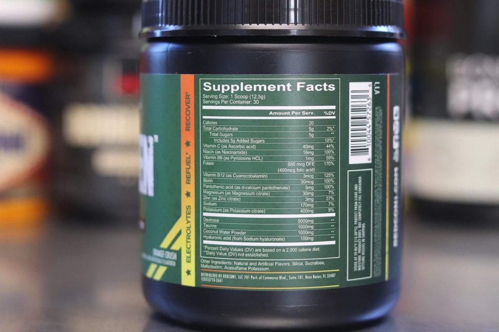 redcon1 canteen tub with green label showing supplement facts in the foreground with blurry supplement tubs in the background