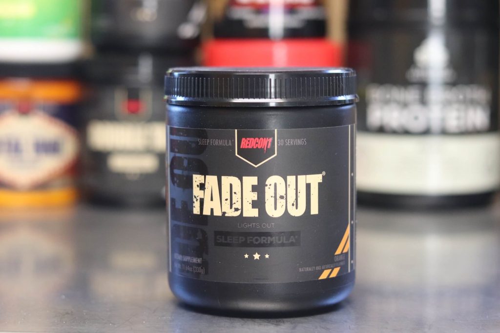 black tub of redcon1 fade out lights out sleep formula orange flavor with black label