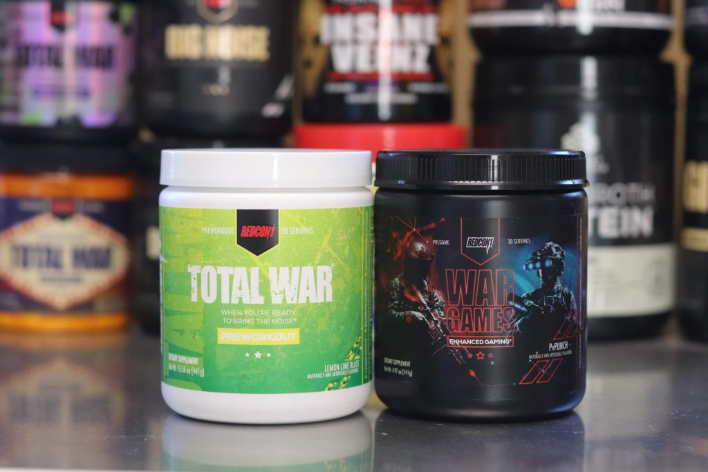 white tub of redcon1 total war lemon lime blast flavor with green label next to black tub of redcon1 war games pv punch flavor with black, blue and red label with 2 gamers on it