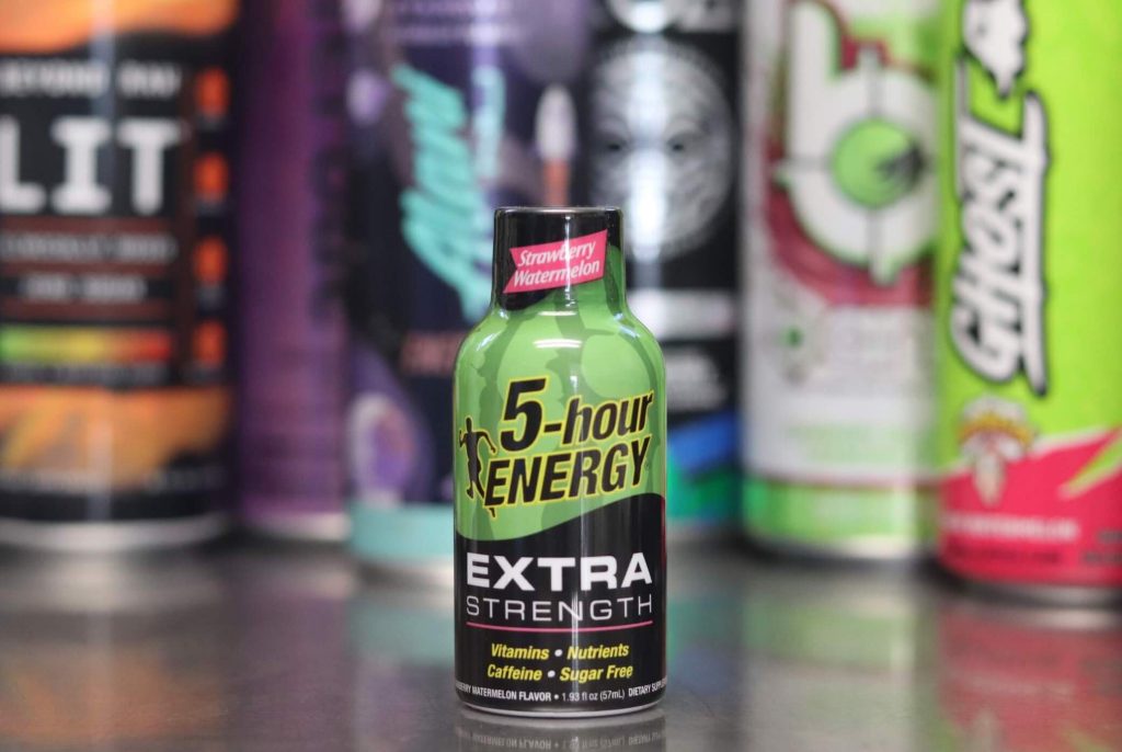 closeup of 5-hour energy strawberry watermelon extra strength with black and green label with background of 6 other energy drink brands