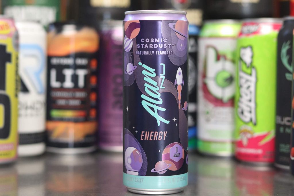 closeup of Alani Nu cosmic stardust naturally flavored energy drink with purple space, planets, rocket and astronaut with background of 8 other energy drink brands