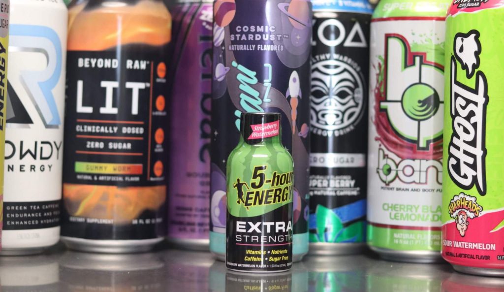 closeup of 5-hour energy drink green and black bottle of strawberry watermelon extra strength with background of 7 other energy drink brands