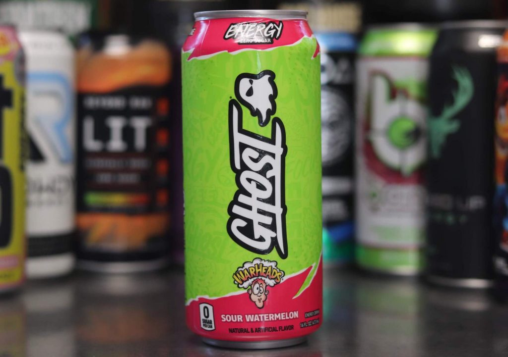closeup of green and pink can of ghost energy warheads sour watermelon flavor with cartoon ghost with background of 8 other energy drink brands