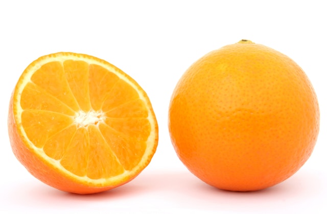 sliced half of a whole orange next to a whole unsliced orange